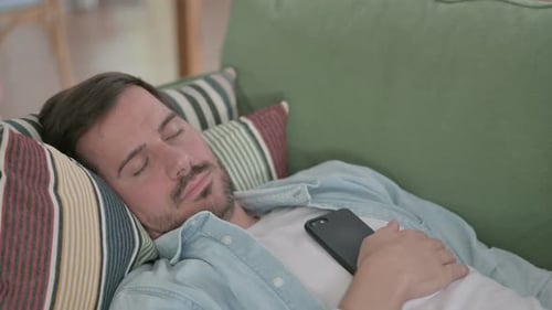 Close Up of Tired Young Man Sleeping While Lying on Sofa