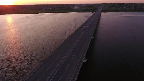 Luftaufnahme einer hohen Brücke über den Dnipro bei violettem Sonnenuntergang im Sommer