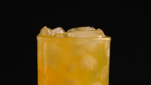 Ice Cubes Splash into Refreshing Orange Beverage