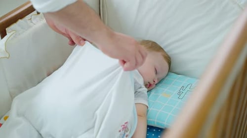 Peaceful Infant Sleeping in Crib with Parent's Care