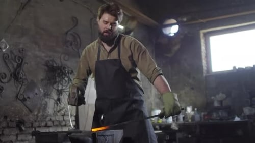 Blacksmith Shaping Hot Metal in Workshop