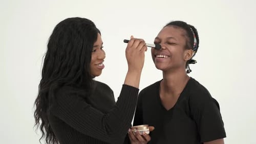African Women Smile and Do Make Up at White Studio