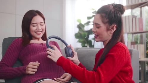 Pregnant Woman Listening to Music with Friend