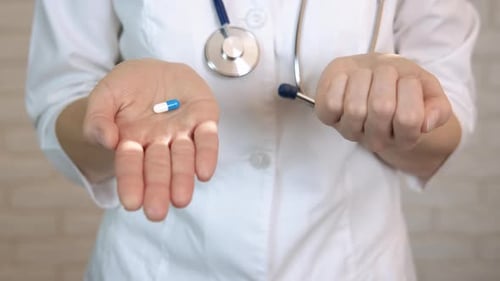 Doctor Holding Medicine Pills in Open Hands