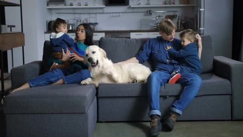 Family with Children and Dog Relaxing on Couch