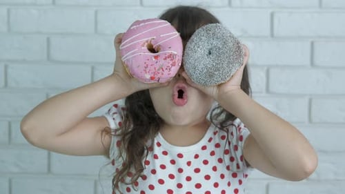 Cheerful kid with donuts.