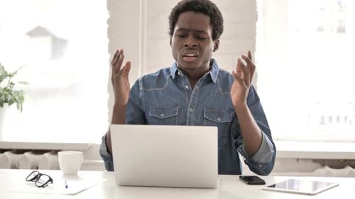 Man Reacts Angrily to Laptop in Bright Workplace