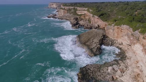 Aerial View of Waves Crashing on Rocky Coastline
