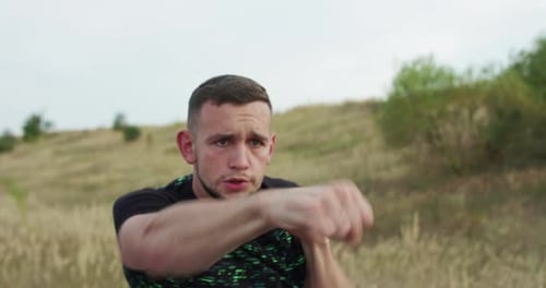 Young Adult Boxing in a Countryside Field