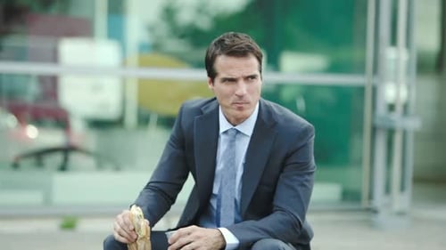 Businessman Having Lunch Break Outside Office Building