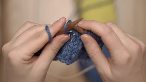 Hands Knitting with Blue Yarn Close Up