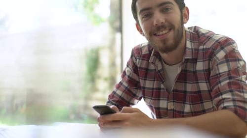 Happy Bearded Man Using Phone Inside