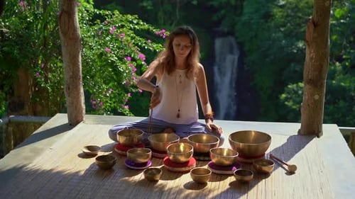 Woman Plays Singing Bowls in Tropical Nature Setting