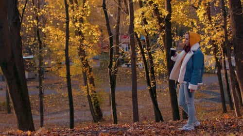 Young Woman Drinking Coffee in Autumn Forest