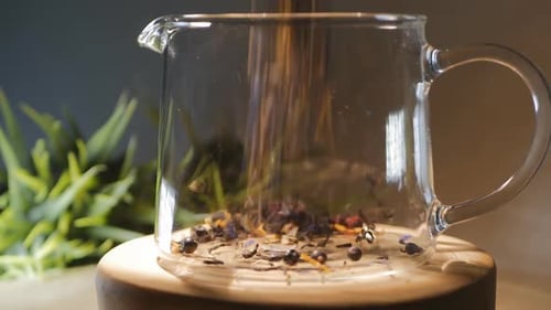 Loose Leaf Tea Pouring into Clear Glass Pitcher