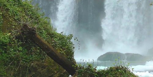 Picturesque Waterfall Flowing Through Lush Green Nature