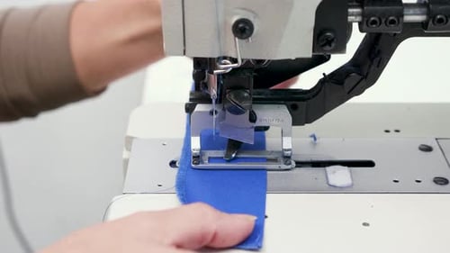 Close Up of Female Worker in a Textile Factory Cutting Holes for Button on Piece of Cloth