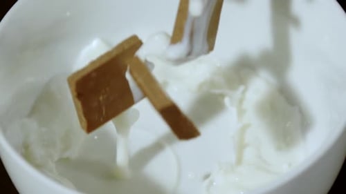 Milk Pouring into Bowl with Pieces of Chocolate