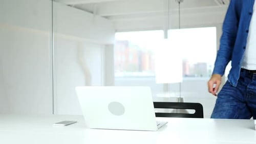Man Coming to Work in Morning Starts Work on Laptop
