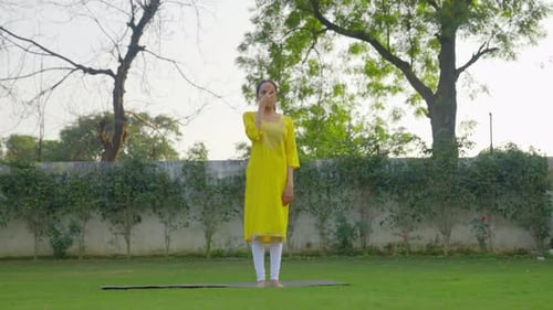 Indian woman doing Anulom Vilom Pranayam or Yoga in Indian outfit