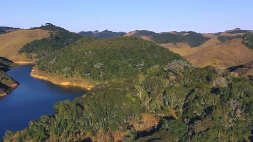 Aerial View of Green Hills and a Scenic Lake