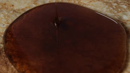 Rotierende Pfannkuchen und Sirup laufen drauf