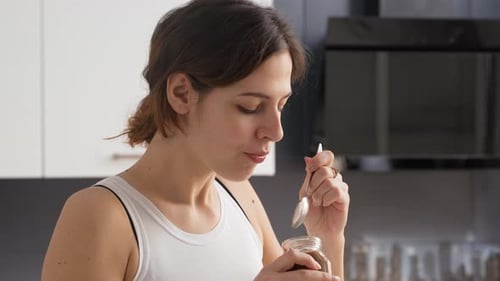 Woman Enjoying Chocolate Spread in Modern Kitchen