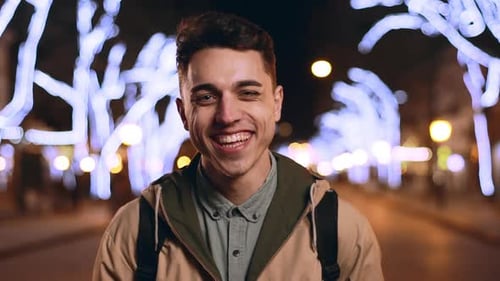 Portrait of Joyous Happy Guy 20s Laughing in Slow Motion While Strolling in Evening City Across Main