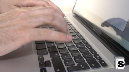 Hands Typing on Laptop Keyboard Close Up