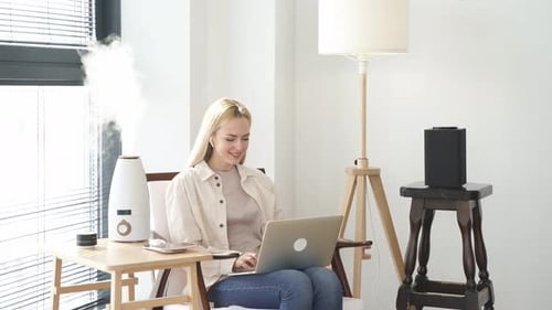 Woman Working on Laptop at Home With Humidifier