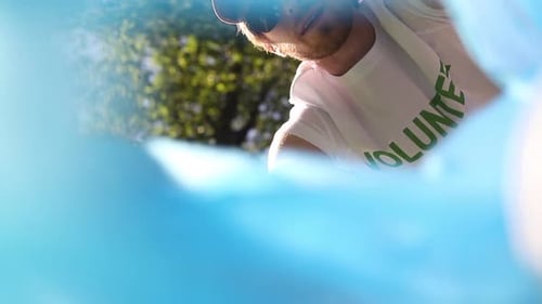 Bottom View of Family Recycle Plastic Bottle Man with Volunteer Tshirt Finishing Cleanup By Closing
