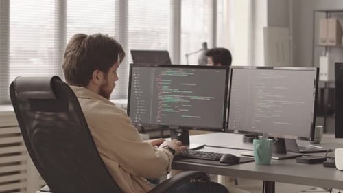 Programmer Typing Program Code on Computer