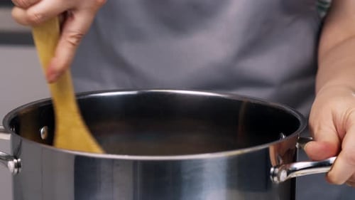 Stirring Food in a Pot with Wooden Spoon