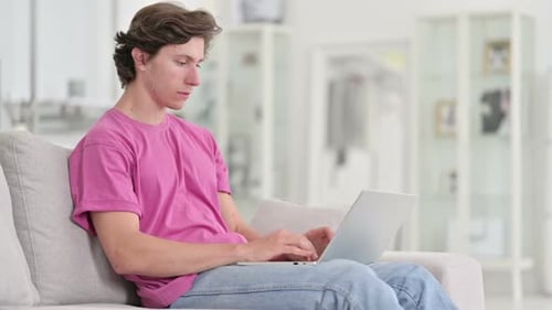 Young Adult Using Laptop Computer at Home