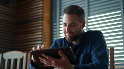 Young Man Uses Tablet Indoors