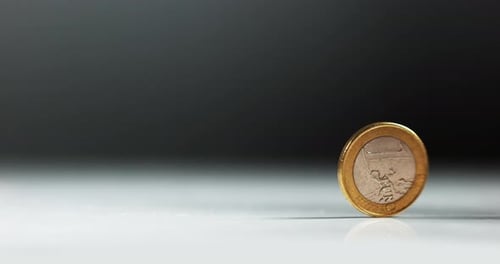 Münze von 1 Euro rollt vor weißem Hintergrund, Zeitlupe 4K
