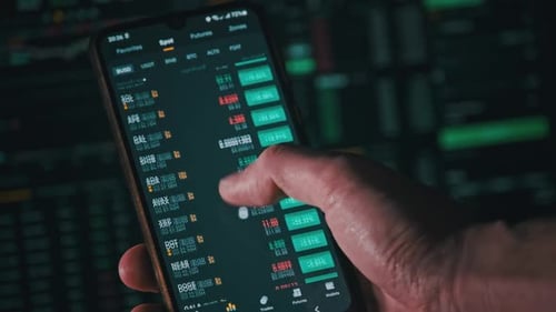 Fingers scrolling through stock market data on smartphone