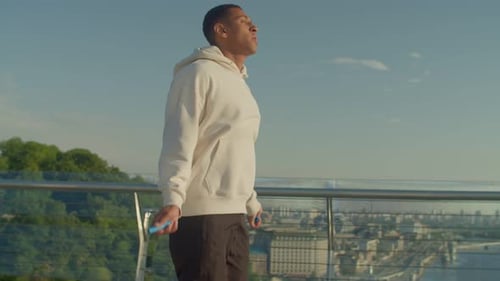 Man Skipping Rope on City Bridge