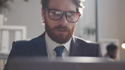 Young Caucasian Businessman Talking on Video Call on Laptop in Office