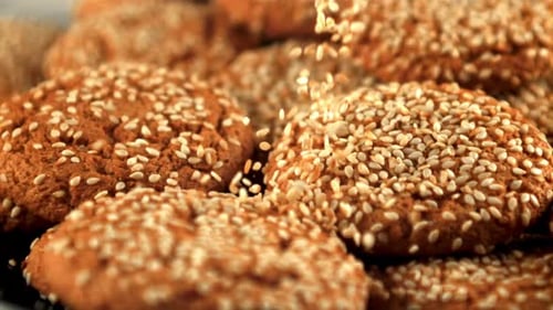 Fresh Cookies with Sesame Seeds Falling in Slow Motion