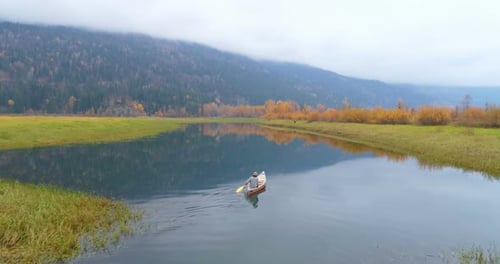 Man rowing boat with his dog on a lake 4k