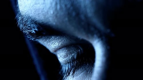 eye of a young man opening in the dark- macro