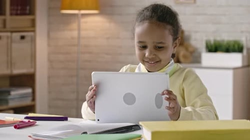 Young Child Using a Tablet at Home at Desk