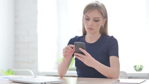Woman Using Smartphone in Office