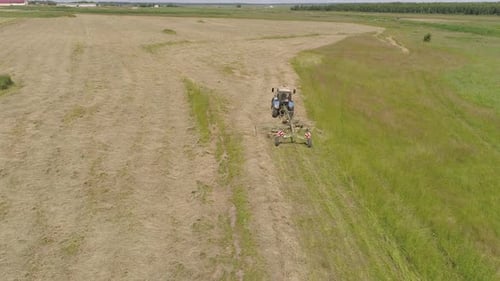Trator com Rake Tedders no campo agrícola