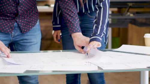 Close Up of Construction Engineer Hands Opening Blueprints