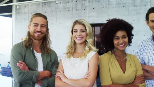 Diverse Team Smiling with Arms Crossed in Office