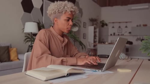 Young Adult Working on Laptop at Home Desk