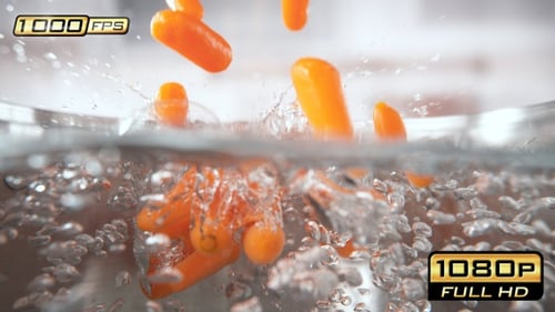 Bright Carrots Falling into Bubbling Water in Kitchen