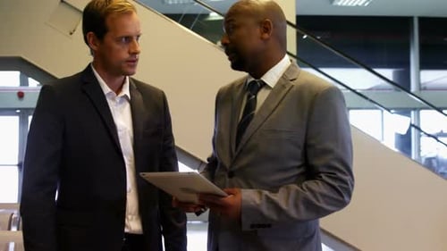 Businessmen Discussing Strategy in Modern Office Lobby